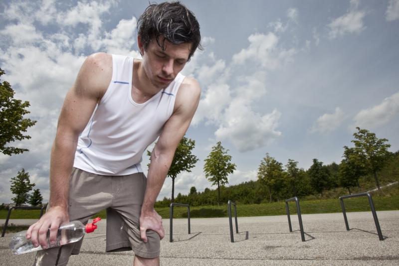 Exhausted runner with water bottle